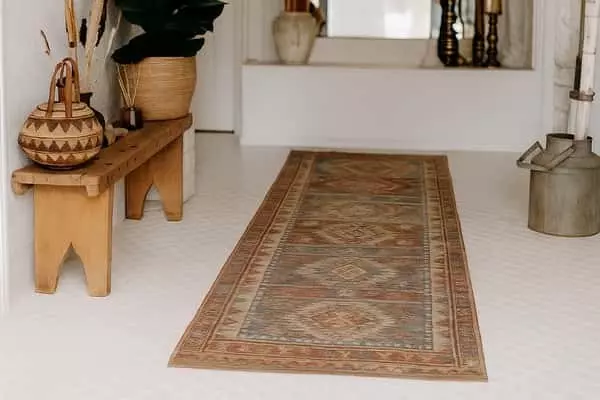 Bohém, kopott hatású kilim futószőnyeg fehér előtérben, natúr fa paddal