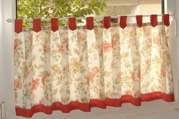 Meleg hangulatú, virágmintás vitrázs függöny piros szegéllyel és textil fülekkel