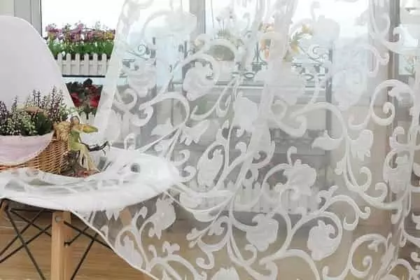 Fehér jacquard függöny gazdag indás-virágos mintázattal, erkélyajtó előtt