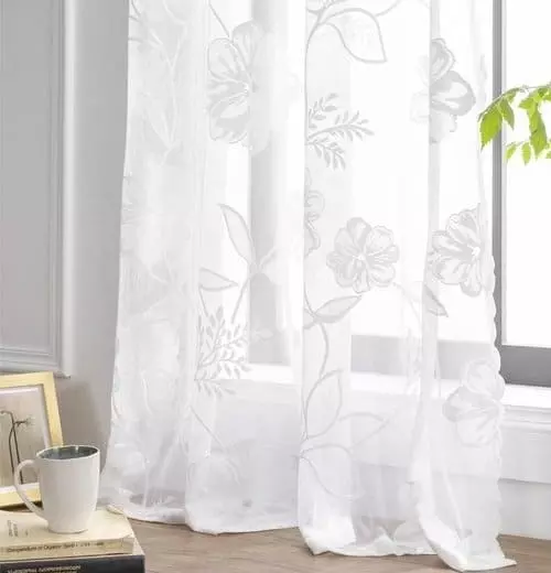 Jacquard függöny ablak előtt, elegáns mintázattal és természetes fénnyel