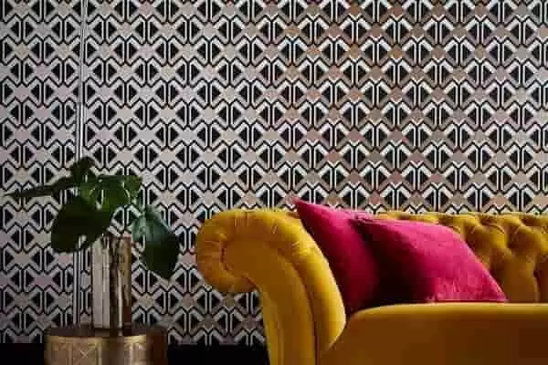  Színes art deco mintás tapéta mustársárga bársony kanapéval és élénk párnákkal